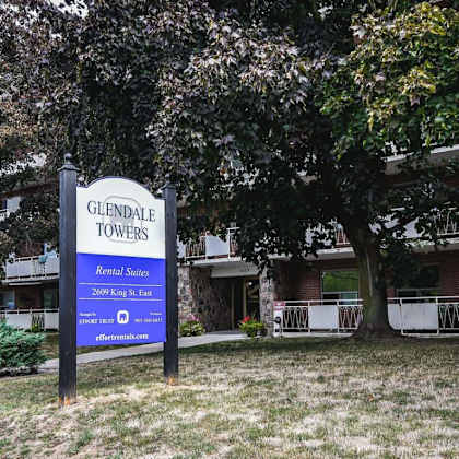 a sign for glendale towers stands in front of a building.