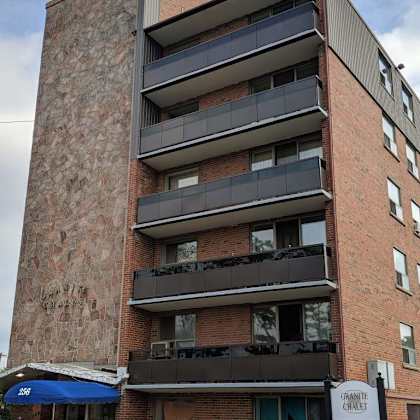 a tall brick building with balconies and awnings.