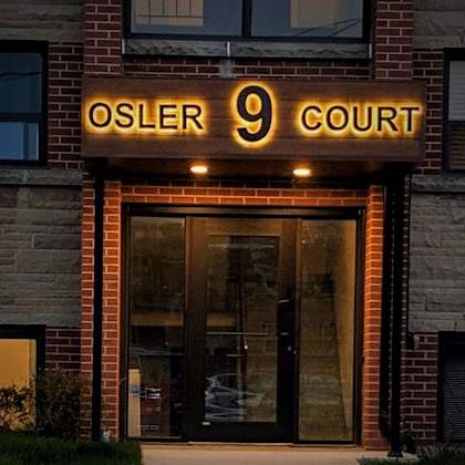 the front of a building with a glass door and a sign that says osler 9 court.