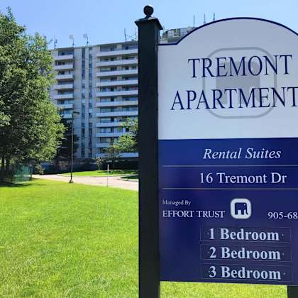 a sign for tremont apartments with a blue background and white text.