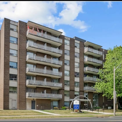 a large apartment building with a blue sign in front.