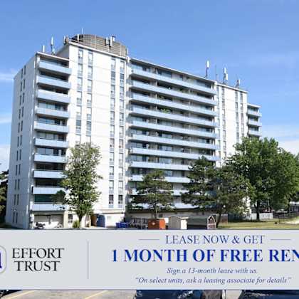 a large white building with a sign in front that says "effort trust 1 month of free rent".