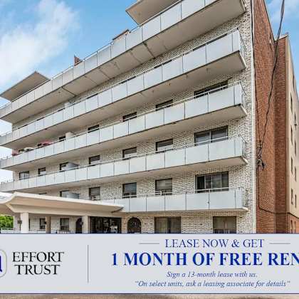a tall apartment building with a sign offering a free month of rent.