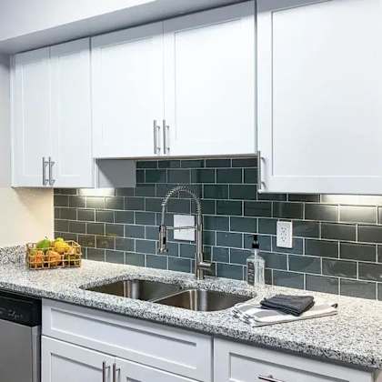 a kitchen with white cabinets and a granite countertop. at latitude at riverchase, hoover