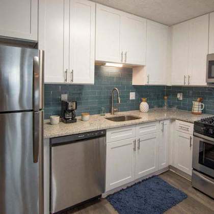 a modern kitchen with a stainless steel refrigerator, microwave, oven, and sink. at paces ridge at vinings, atlanta