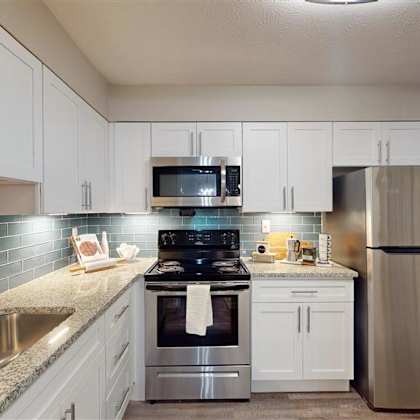a kitchen with a stainless steel refrigerator, sink, and stove. at vinings rivervue, georgia, 30339