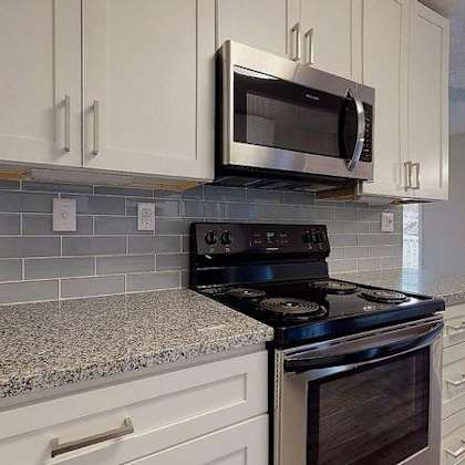 a kitchen with a black stove top oven and a microwave above it. at spalding vue, peachtree corners, 30092