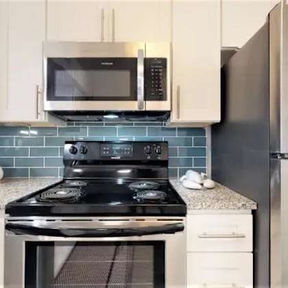 a kitchen with a black stove top oven and a black refrigerator. at cumberland pointe, georgia, 30080