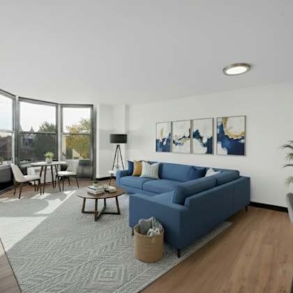 a modern living room with a blue sofa and a grey rug at fullerton court apartments, chicago, 60614