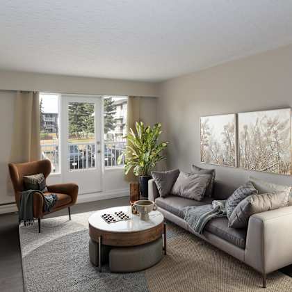 a living room with a grey couch, a brown armchair, a coffee table, and a floor lamp.