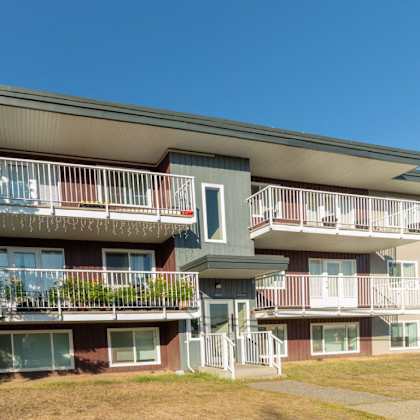 apartment building with balconies and a clear blue sky.