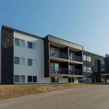 a modern apartment building with balconies and a clear sky.