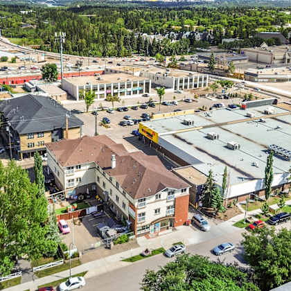 a parking lot is surrounded by buildings and trees.