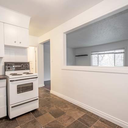 a kitchen with white cabinets and a tiled floor.