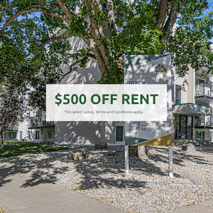 a sign offering $500 off rent is displayed in front of a building.