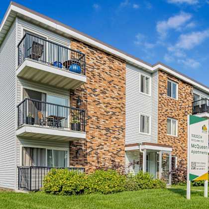 a multi-story apartment building with a sign that reads "stonebridge meadows apartments.".
