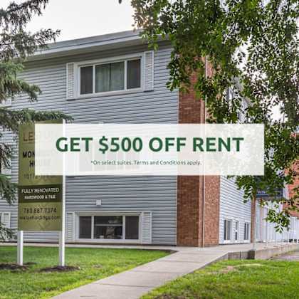 a sign offering $500 off rent is displayed in front of a building.