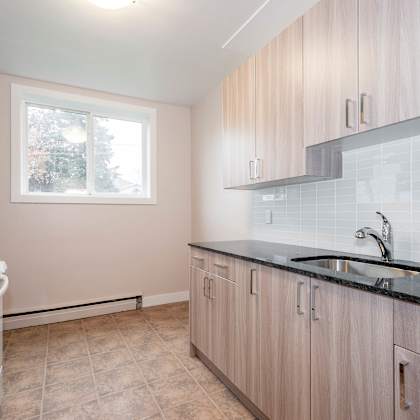 a kitchen with a white refrigerator and wooden cabinets.