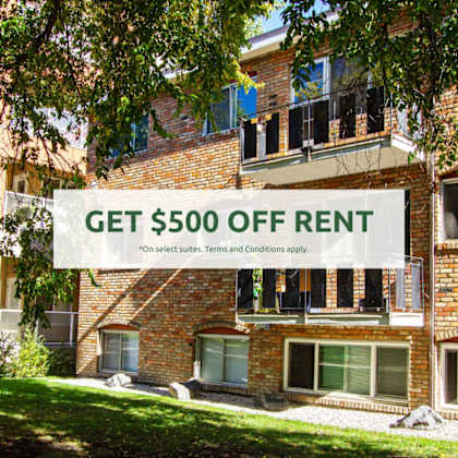 a sign offering $500 off rent is displayed in front of a brick building.