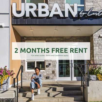 a person is sitting on the steps of a building with a sign that reads "urban 2 months free rent".