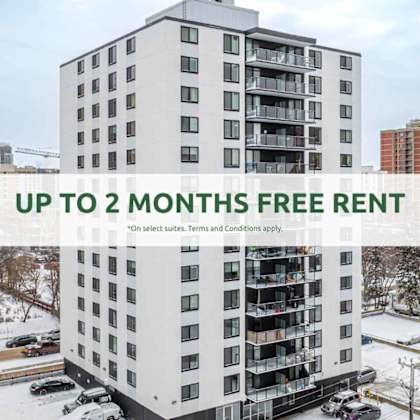 a tall white apartment building with a sign offering up to 2 months free rent.