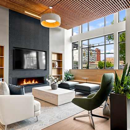 a modern living room with a fireplace and a green chair.
