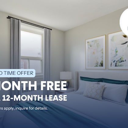 a bedroom with a bed, pillows, and pictures on the wall, advertising a limited time offer for a free month on a 12-month lease.