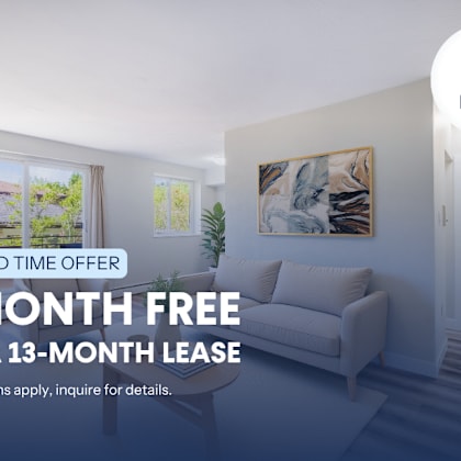 a room with a couch and a painting on the wall, advertising a free month on a 13-month lease.