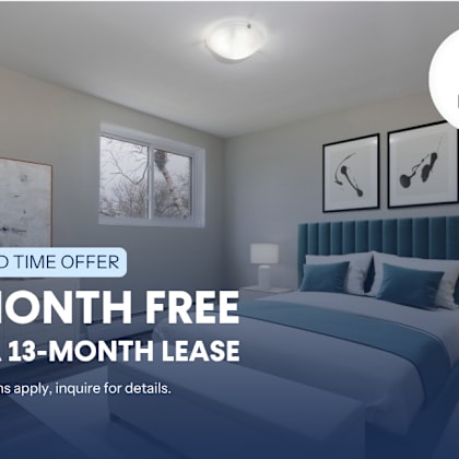 a bedroom with a bed, two nightstands, and a window with a view of a tree.