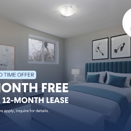 a bedroom with a bed, nightstands, and pictures on the wall, advertising a limited time offer for a free month on a 12-month lease.