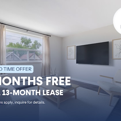 a room with a chair and a television mounted on the wall, advertising a limited time offer for a free 2 months on a 13-month lease.