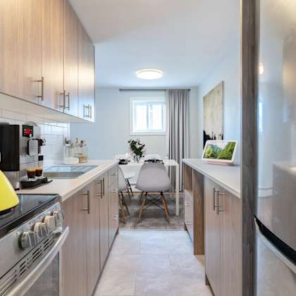 a modern kitchen with a yellow kettle on the stove.