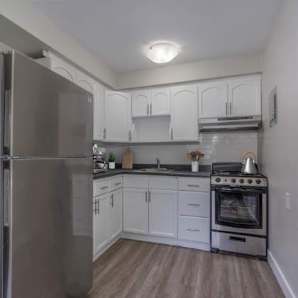 a kitchen with a refrigerator, oven, and cabinets.