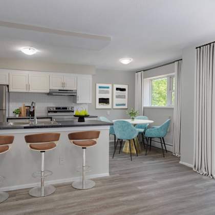 a kitchen with a bar area and a dining table with chairs.
