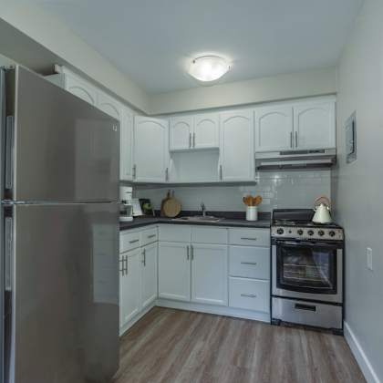 a kitchen with a stainless steel refrigerator and a stove with a pot on it.