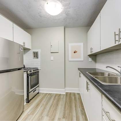 a kitchen with a refrigerator, oven, and sink.