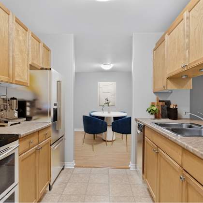 a kitchen with wooden cabinets and a table set for two.