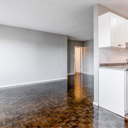 a kitchen with white cabinets and a wooden floor.