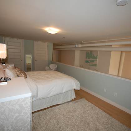a bedroom with a bed, nightstand, and lamp.