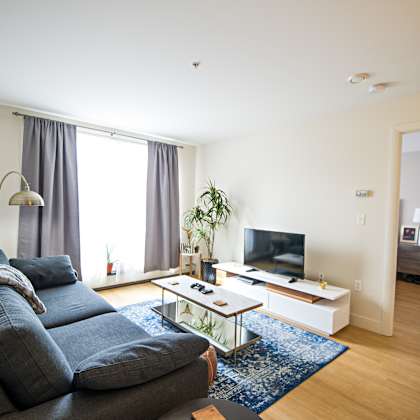 a living room with a grey couch and a white coffee table.