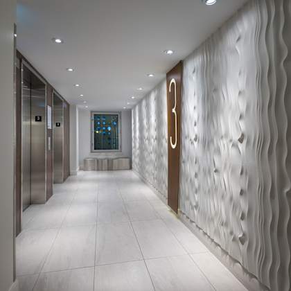 a hallway with a wall of wavy panels and a number 3 on the door.