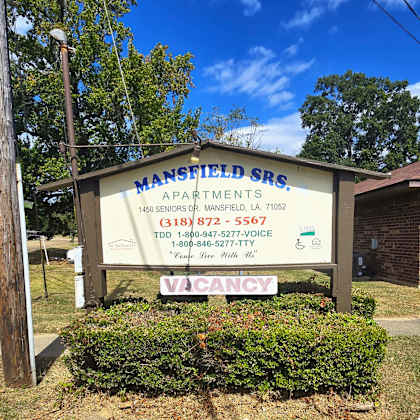 a sign for mansfield senior living apartments is displayed in front of a building.