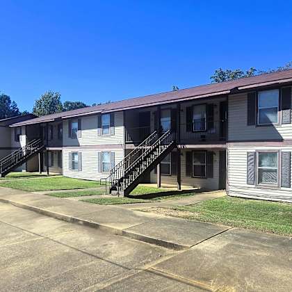 apartment complex with a parking lot in front.