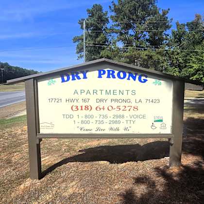 a sign for dry prong apartments with a phone number and address.