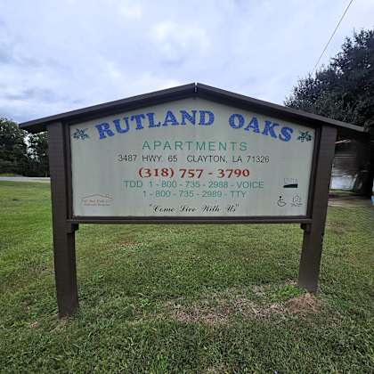 a sign for rutland oaks apartments with contact information.
