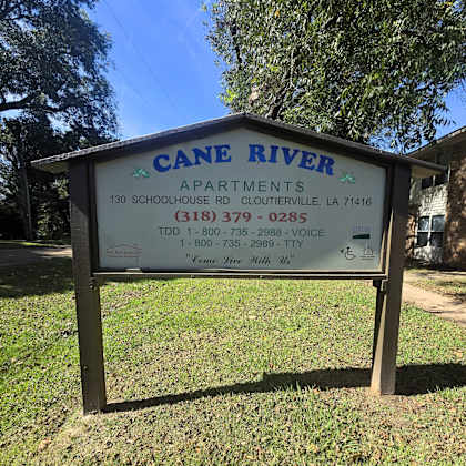 a sign for cane river apartments in cloutierville, la.