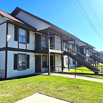 a two-story house with a balcony on the second floor.