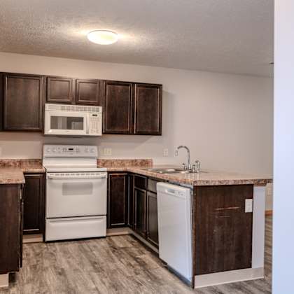 a kitchen with white appliances and brown cabinets.