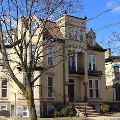 a large, two-story house with a balcony on the second floor.