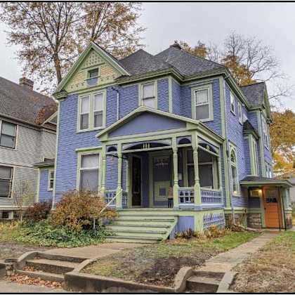 a blue house with a brown door and a small porch.